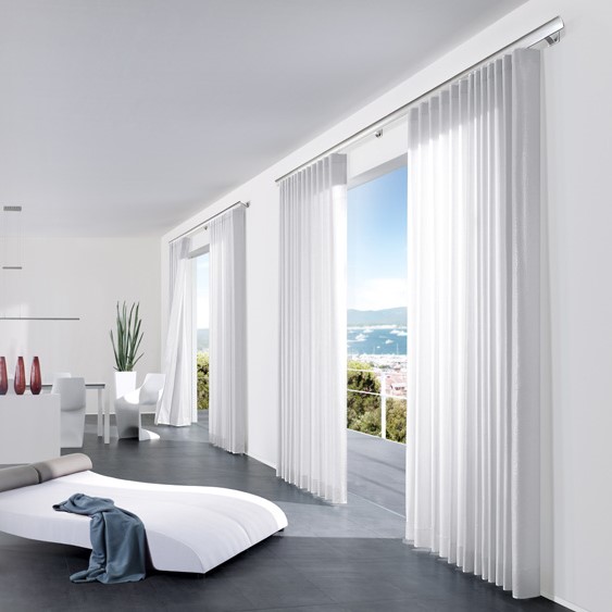 Heller, moderner Raum mit weißen Gardinen und schönem Ausblick. Foto von Interstil.