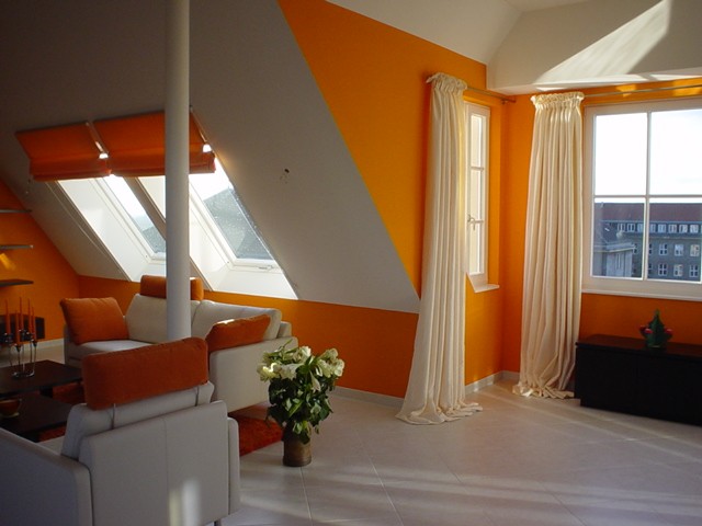 Modernes Dachgeschoss gestaltet mit orangefarbenen Wänden und weißen, schlichten Vorhängen und Faltrollos. Foto aus dem Raumkonzept-Archiv.